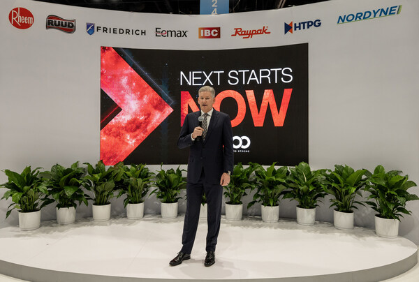 Rheem's Chris Peel in front of "Next Starts Now" sign