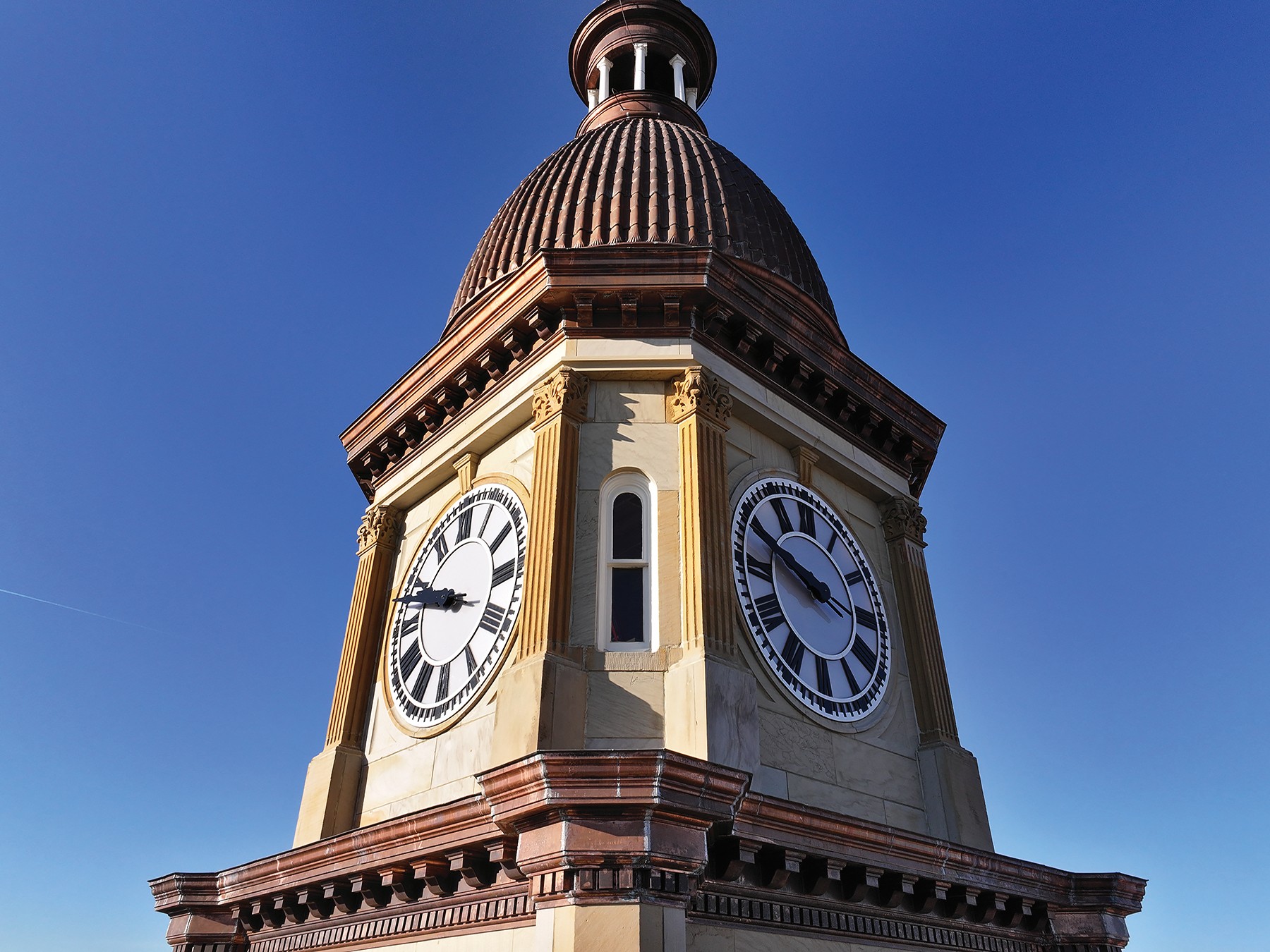 Clock tower of Hillsdale County Courthouse, with dark copper dome and trim