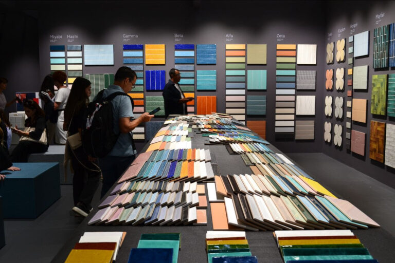Porcelain and ceramic tile samples on a long tiable and wall at CERSAIE 2025