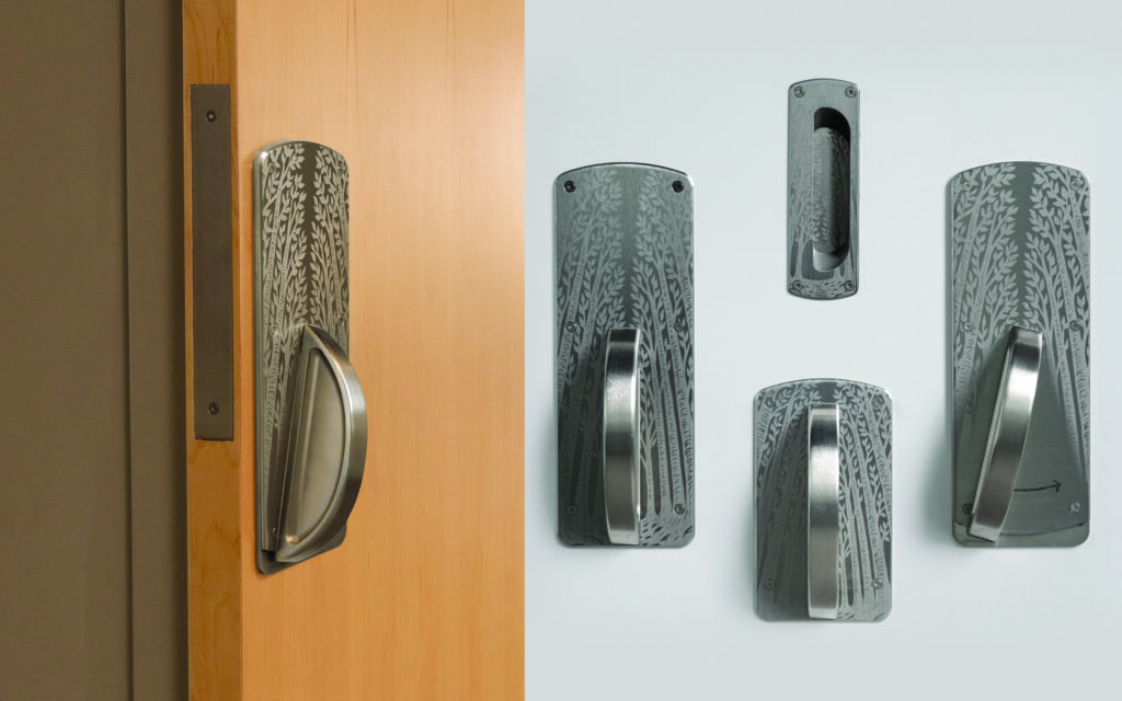 Vertical door handles with tree design on backplate in healthcare setting