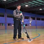 Man using Unger Excella floor-cleaning system on a gym floor